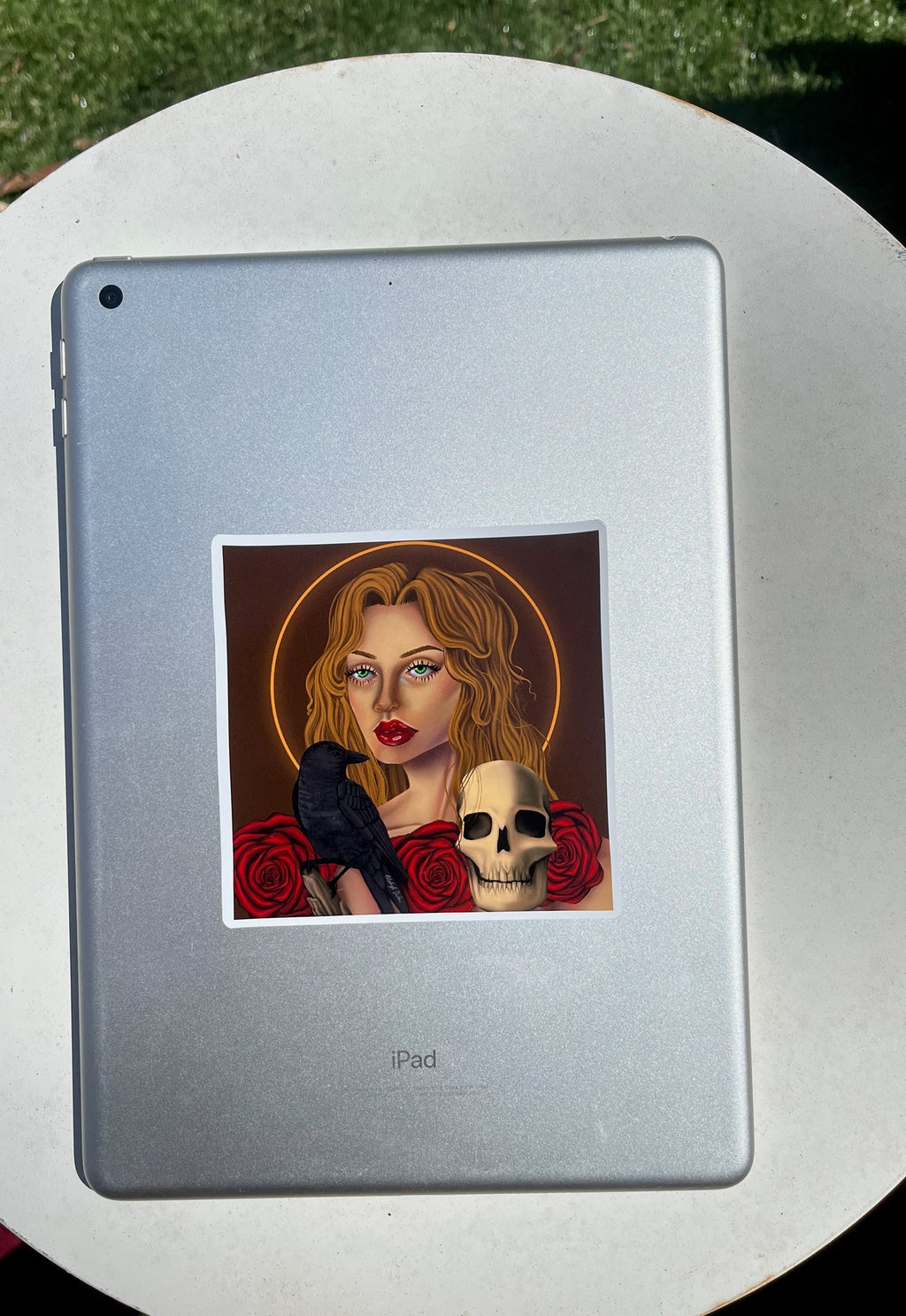 Sticker of a woman with a bird and skull  and roses on an iPad