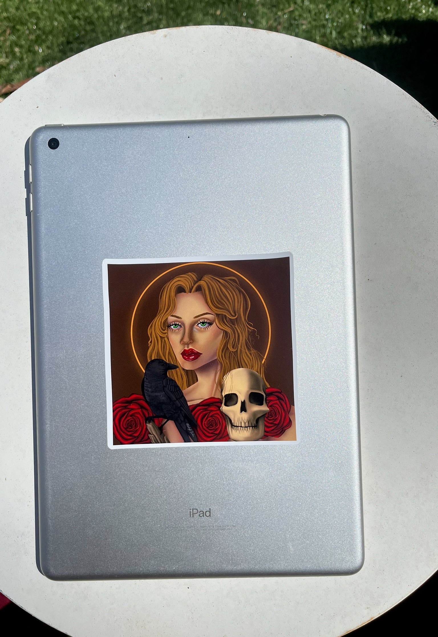 Sticker of a woman with a bird and skull  and roses on an iPad